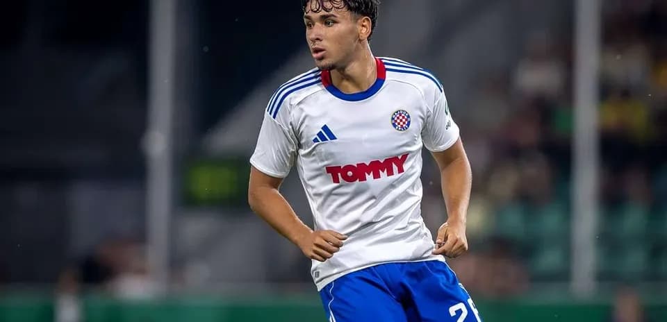 Futbolchi o'yinda harakatda, oq futbolka kiygan