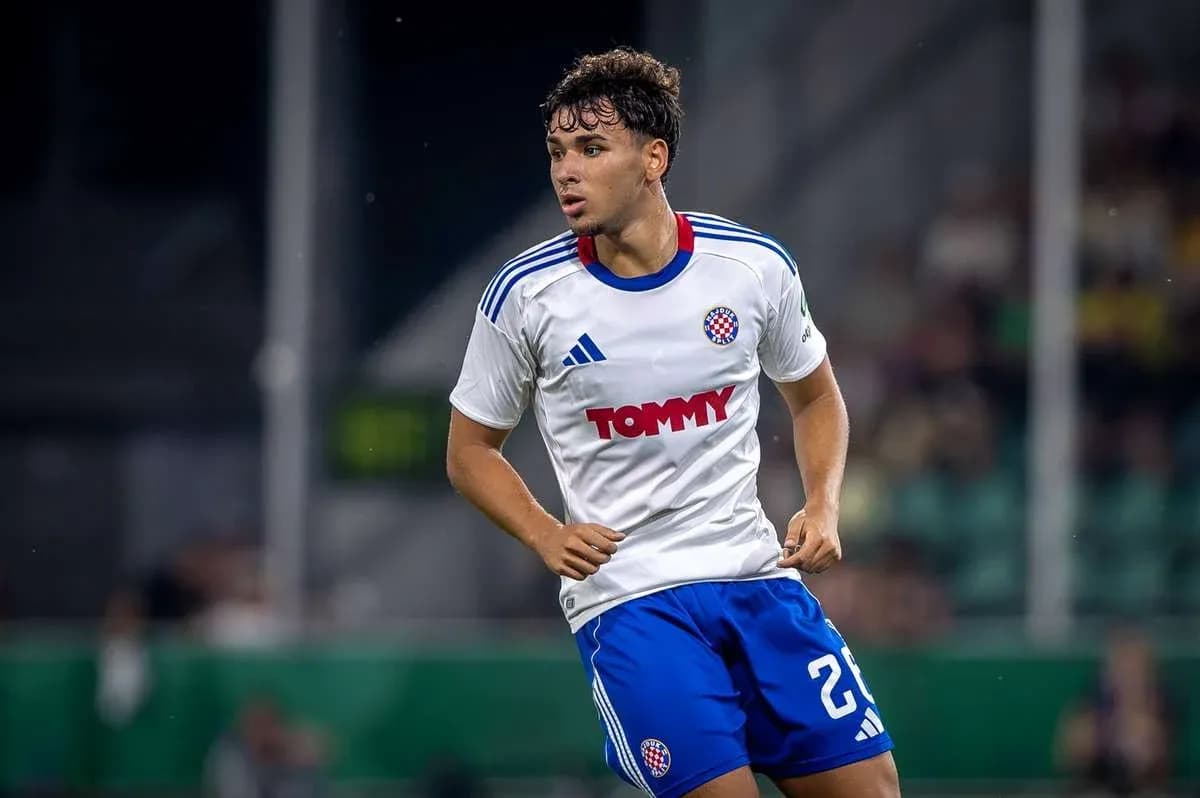 Futbolchi o'yinda harakatda, oq futbolka kiygan