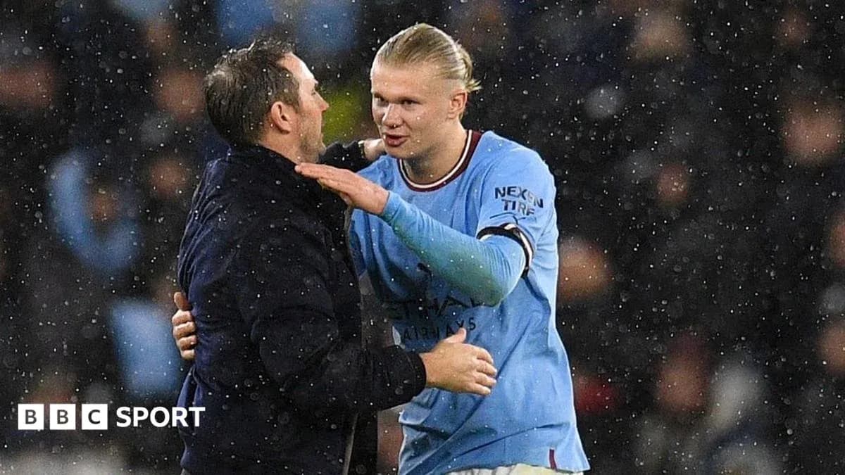 Erling Haaland embracing coach during rainy match
