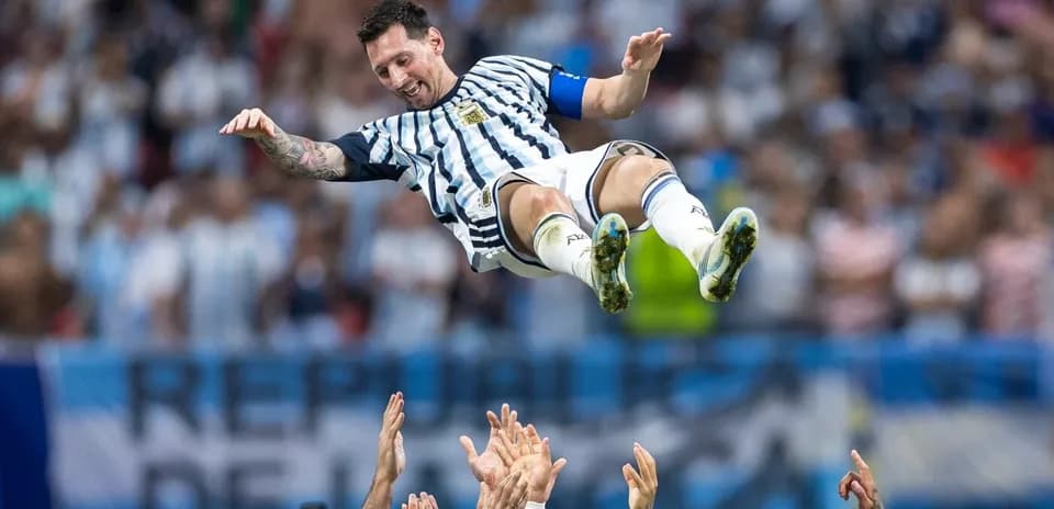 Futbolchi Messi hoshimda ko'tarilgan holda sakrayapti