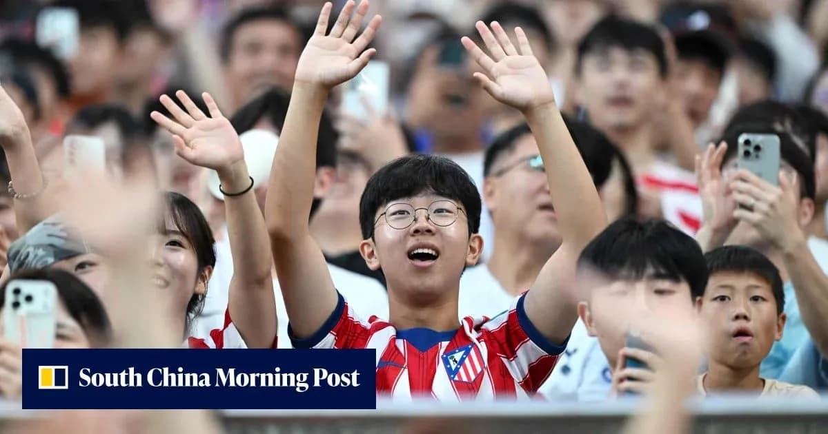 Fans cheering in Atletico Madrid jerseys at stadium