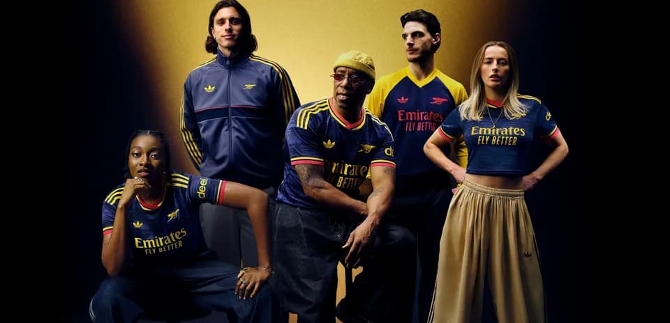 Five individuals posing in Arsenal jerseys and apparel