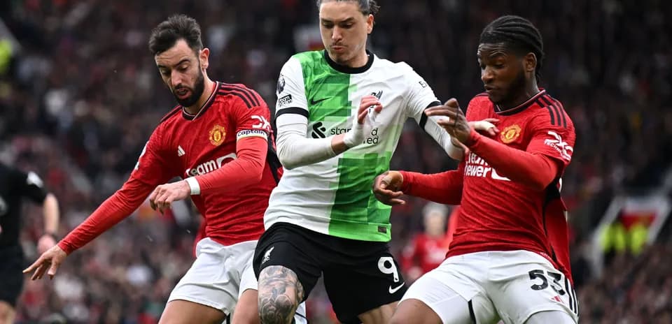Liverpool and Manchester United players battling for possession
