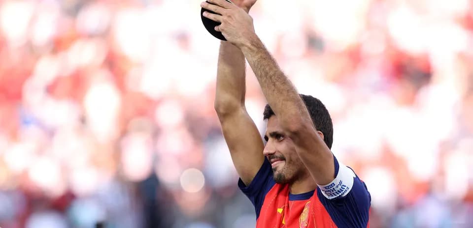 Futbolchi kubokni ko'tarib turib tabriklayapti