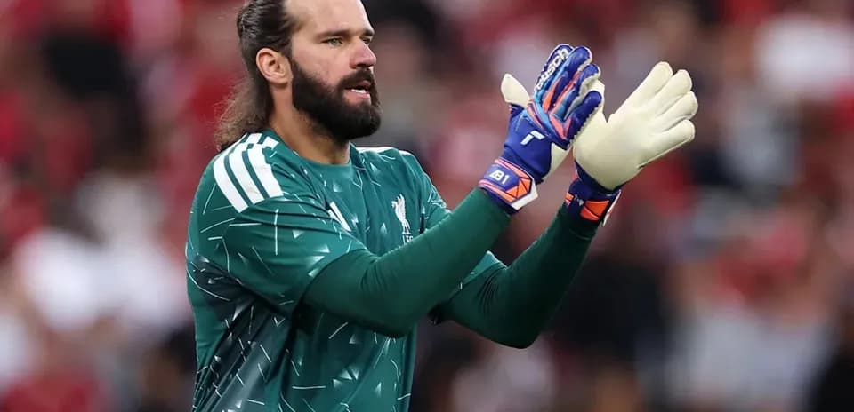 Goalkeeper in green kit clapping during match