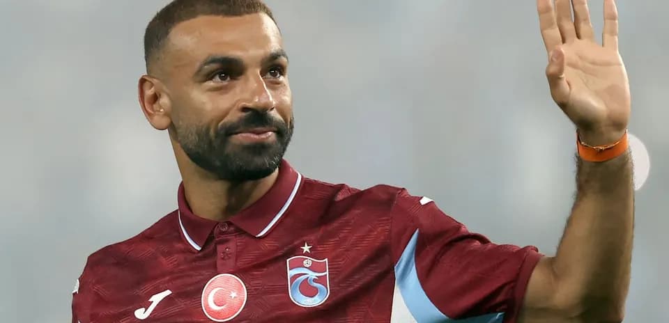 Futbolchi qo'l silkitib tomoshabinlarga salom bermoqda