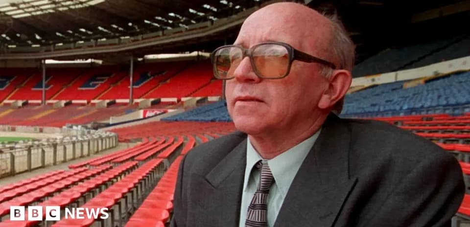 Man in glasses sitting in empty stadium stands