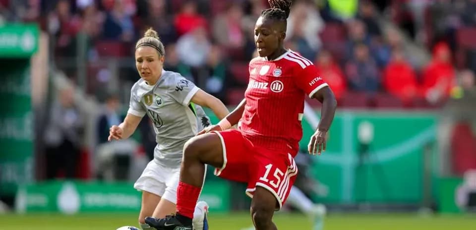 Bayern player controlling ball against Wolfsburg opponent