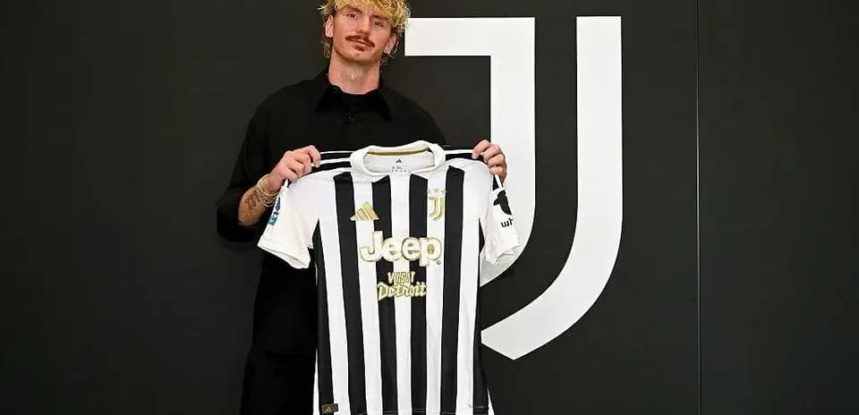 Futbolchi Juventus formasini ko'tarib turibdi