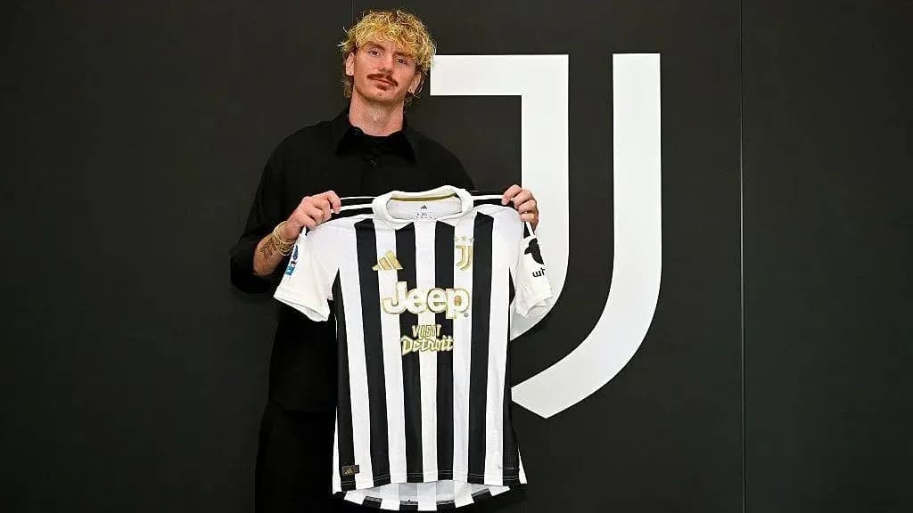 Futbolchi Juventus formasini ko'tarib turibdi