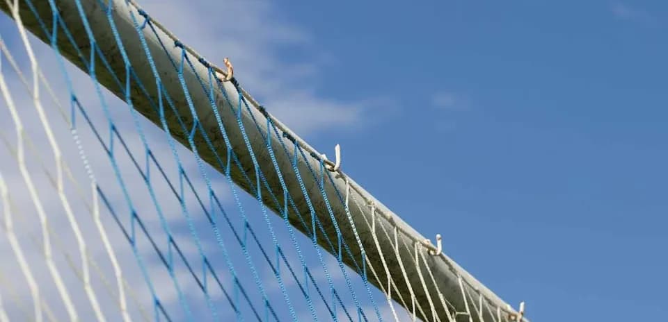 Football goal net against blue sky backdrop