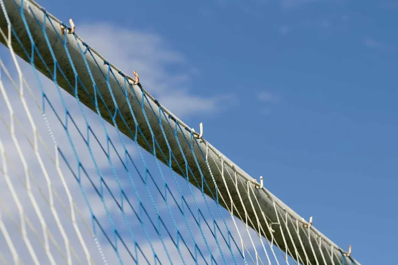 Football goal net against blue sky backdrop