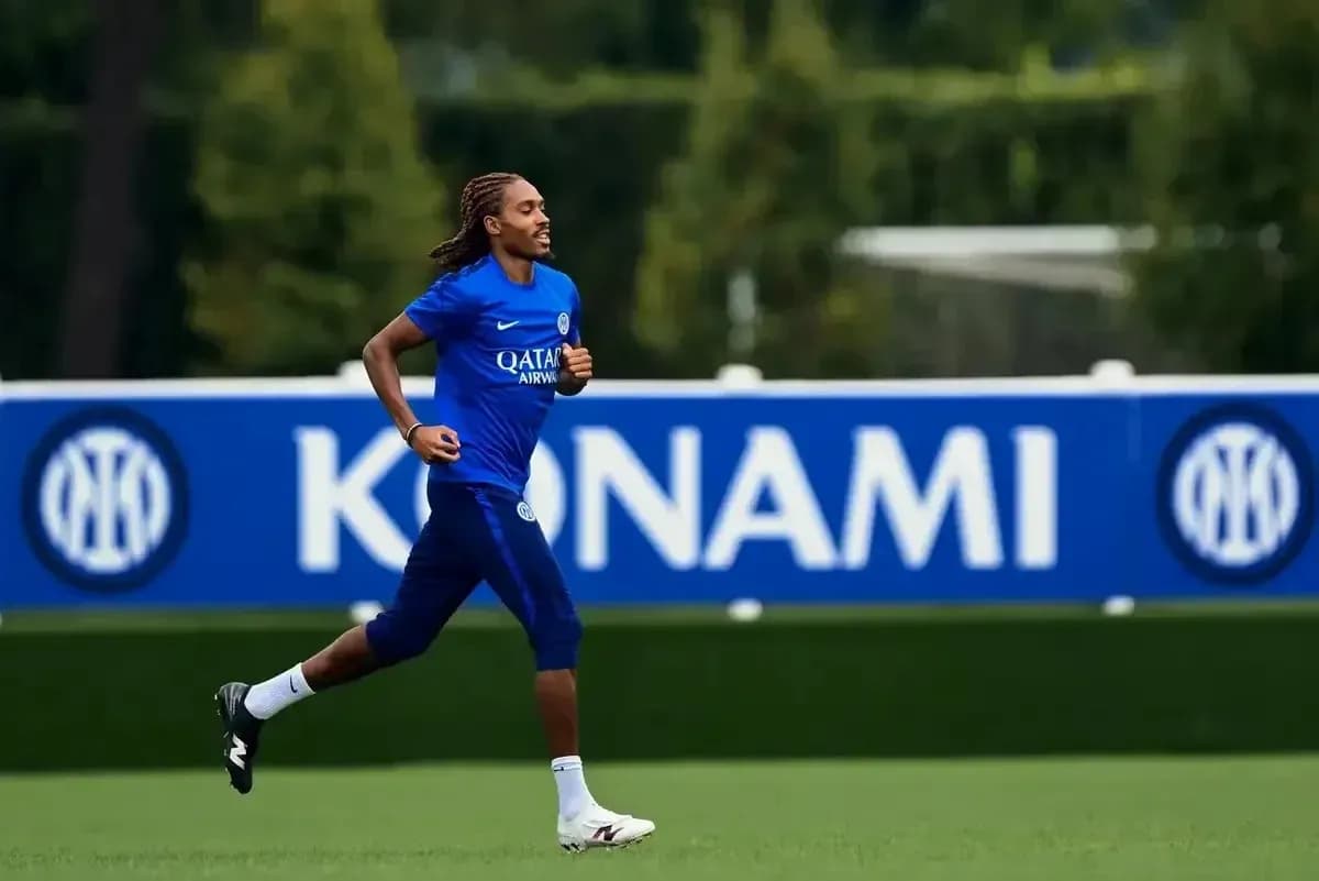 Futbolchi mashg'ulotda yugurmoqda, orqa fonda banner