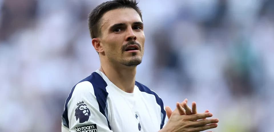 Futbolchi maydonda qo'llarini birlashtirib turgan