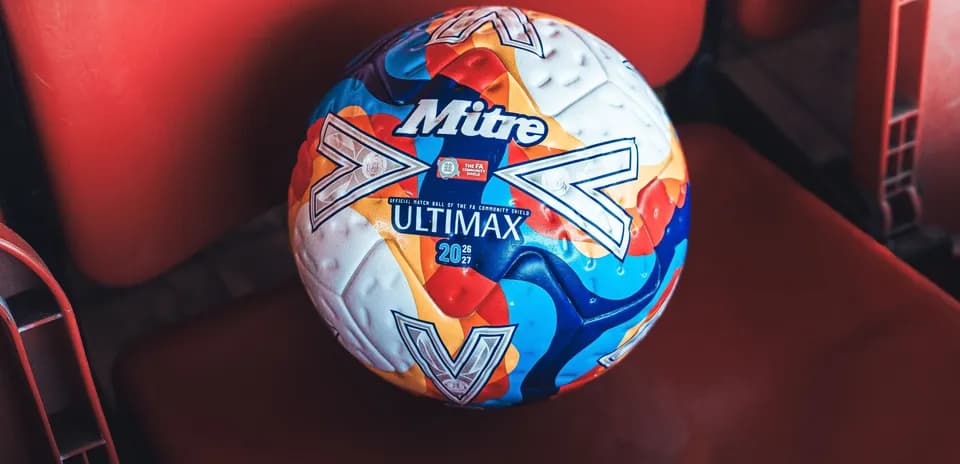 Mitre Ultimax football on red stadium seat