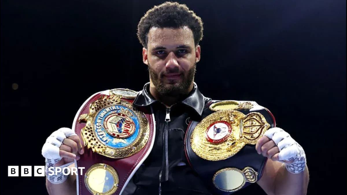 Boxer holding multiple championship belts in ring