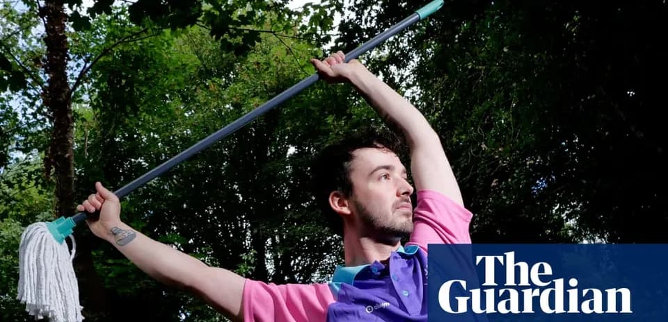 Person holding a mop in a dynamic pose outdoors
