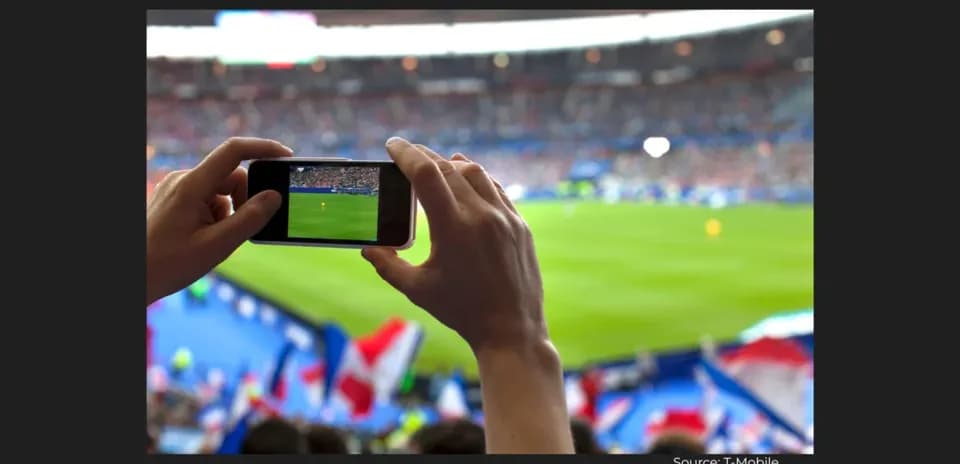 Fan recording football match on smartphone in stadium