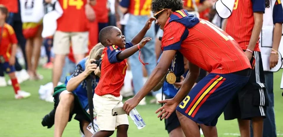 Bola o'yinida g'olib bo'lgan futbolchi va bola