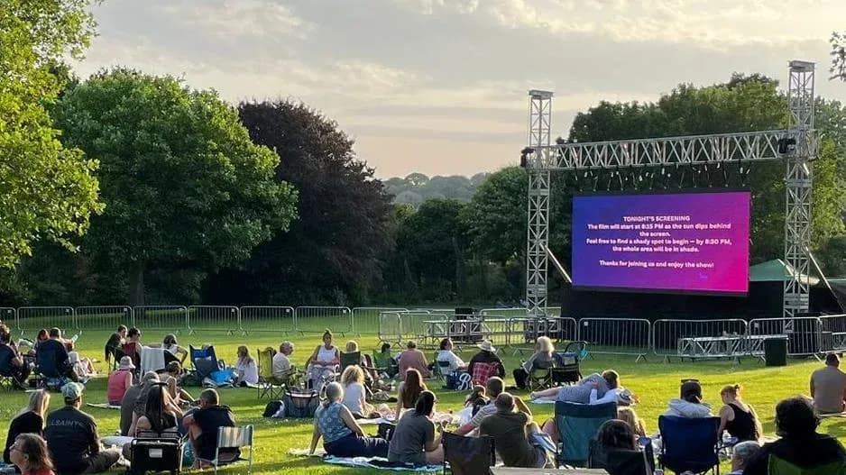 People watching a movie outdoors on a large screen