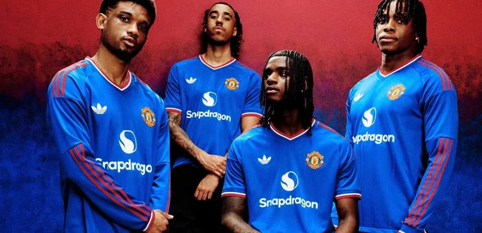 Four players posing in Manchester United jerseys