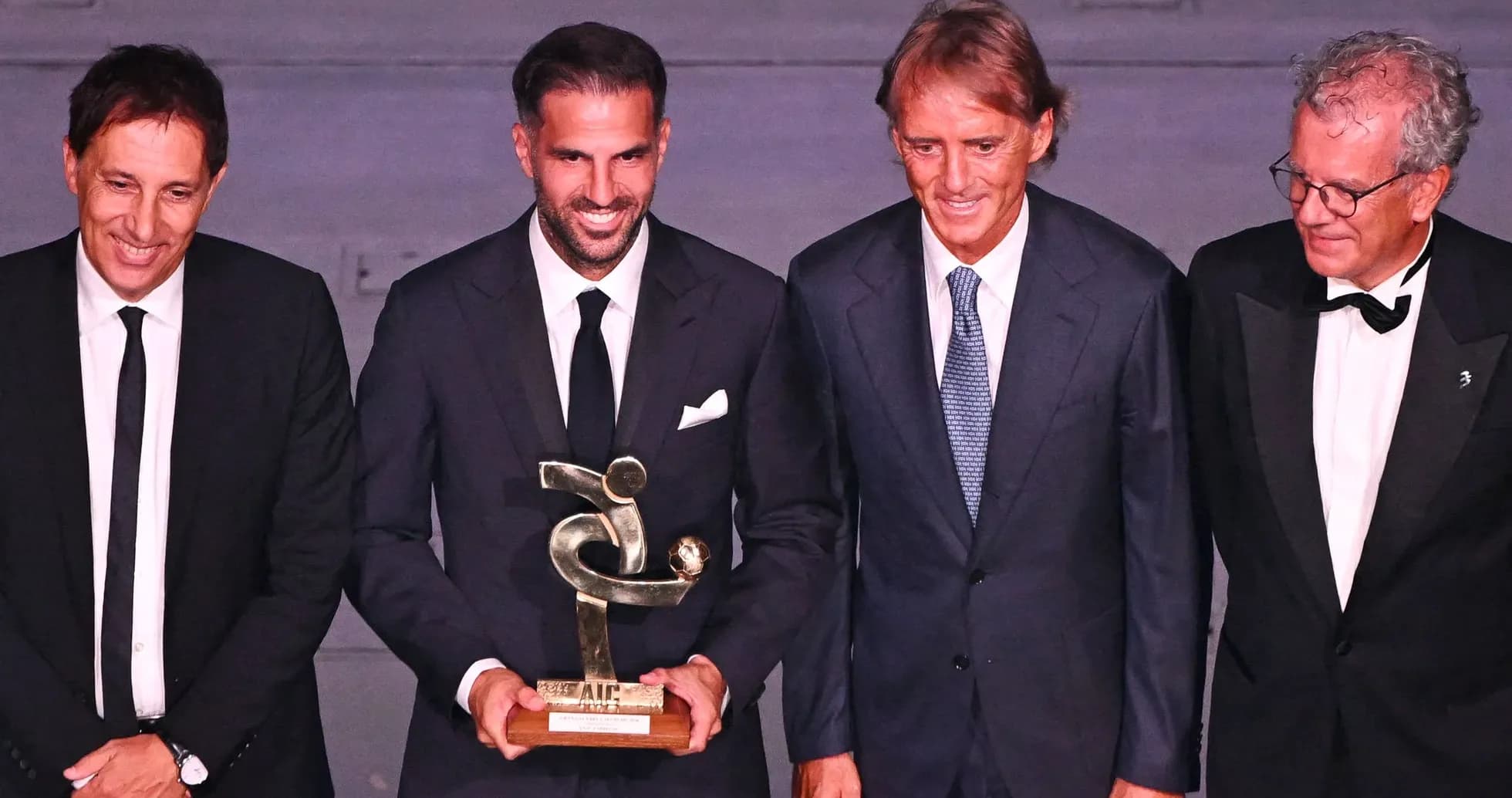 Four men posing with an award at event