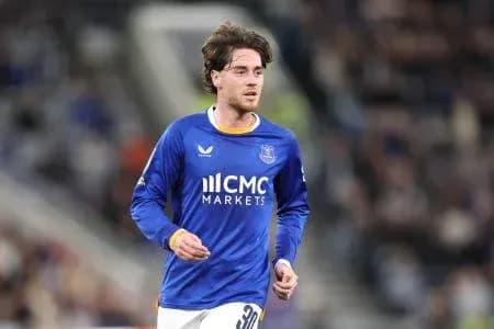 Futbolchi maydonda yugurayotgan ko'k forma kiygan
