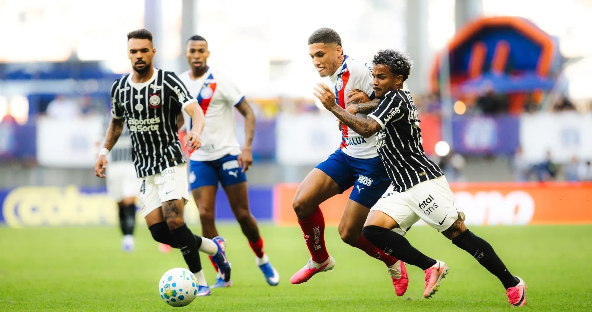 Futbol o'yinida to'p uchun kurashayotgan futbolchilar