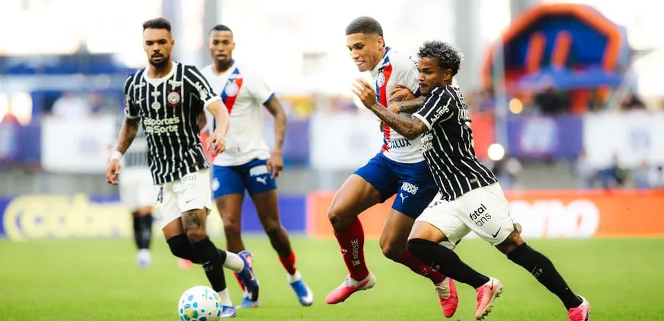 Futbol o'yinida to'p uchun kurashayotgan futbolchilar