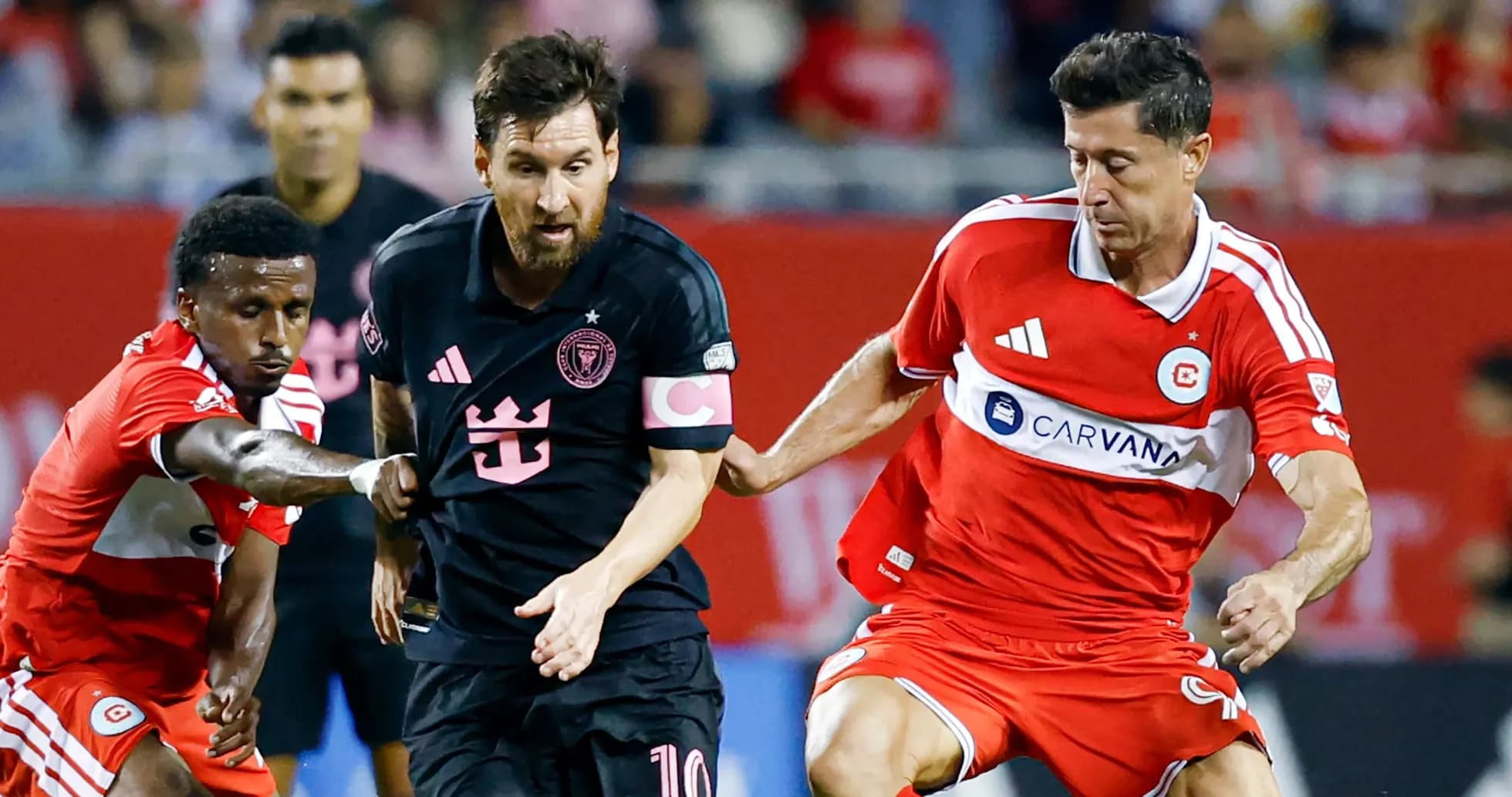 Messi dribbling past defenders in a soccer match