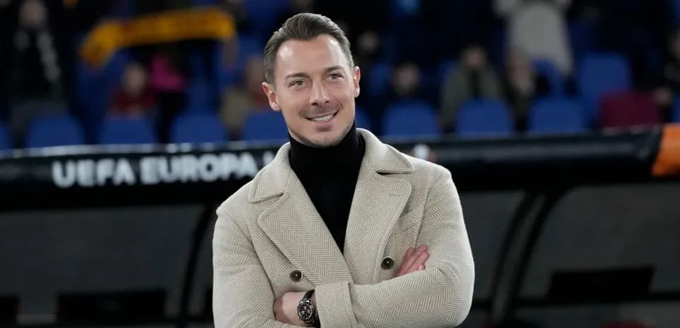 Person in a stylish coat at a football match