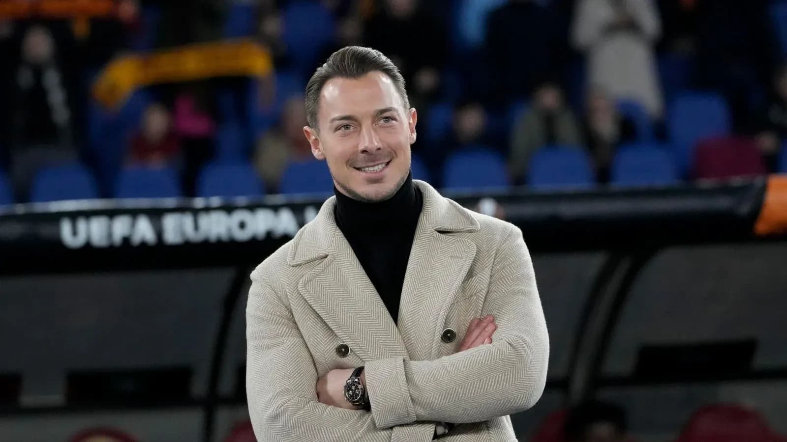 Person in a stylish coat at a football match