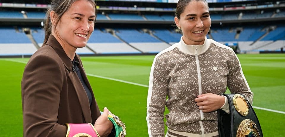 Two female boxers with championship belts on field