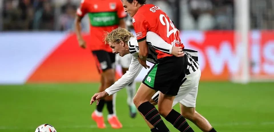 Two players battling for the ball on the pitch