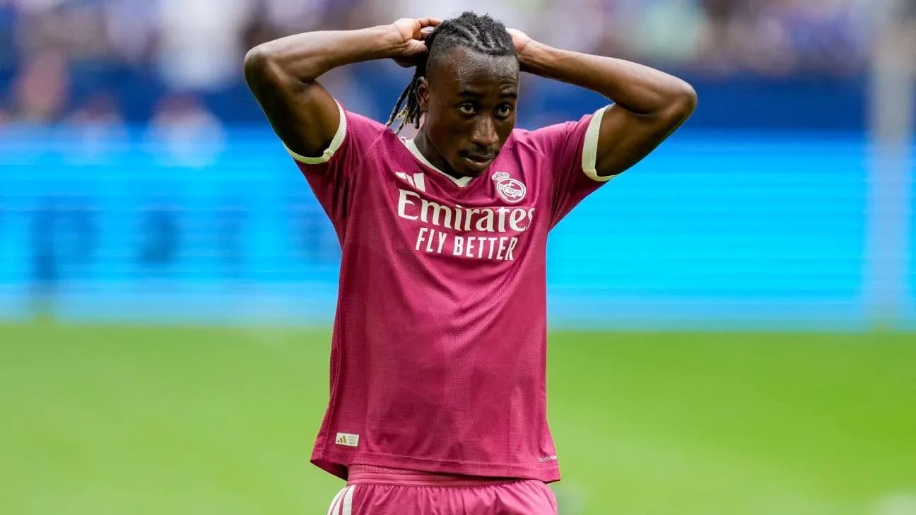 Futbolchi Real Madrid formasida, qo'llarini boshiga qo'ygan