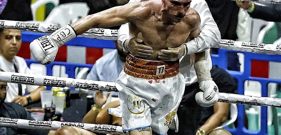 Boxer being helped after a knockout in the ring