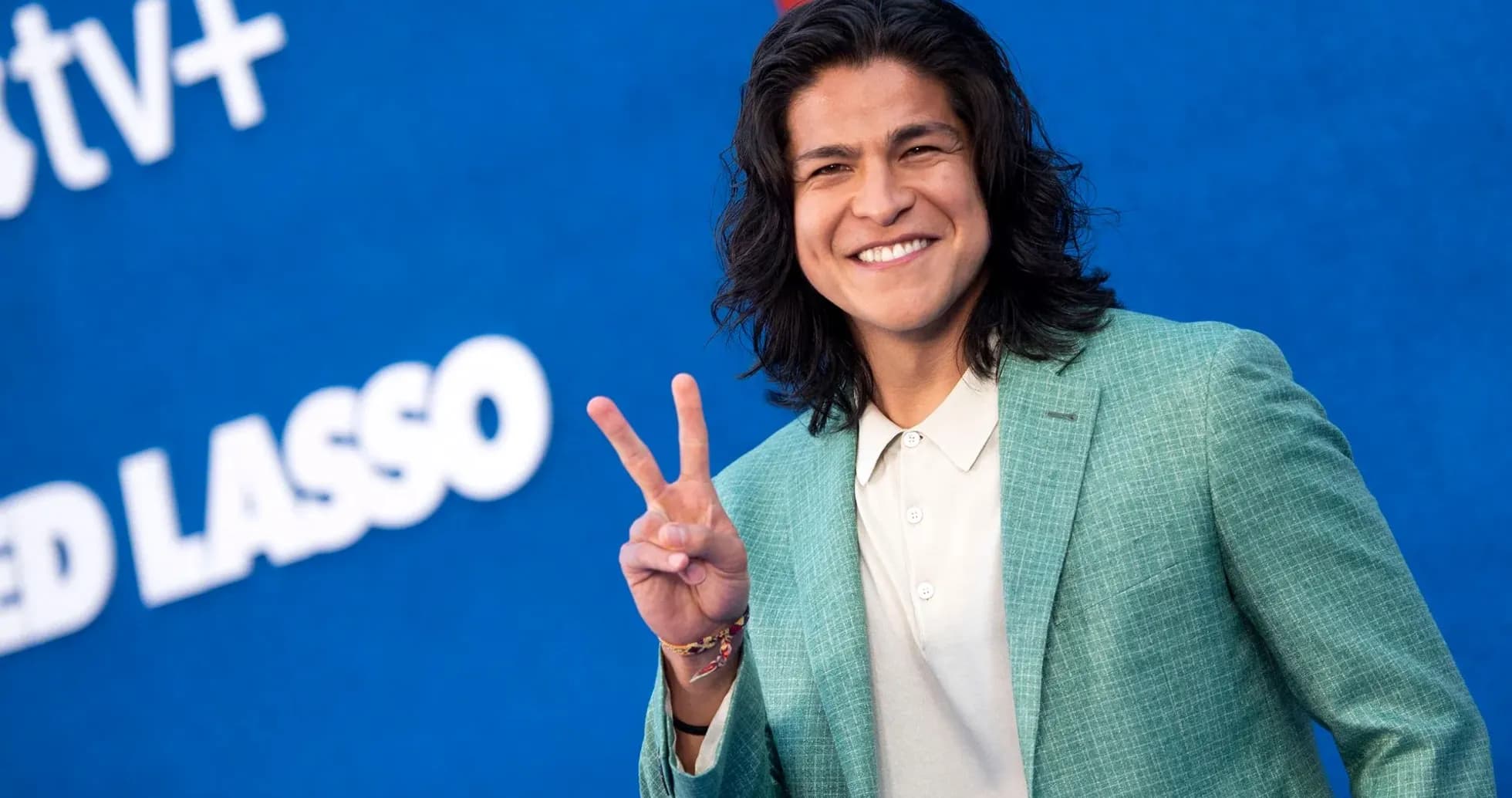 Yoshinori Muto smiling and making peace sign