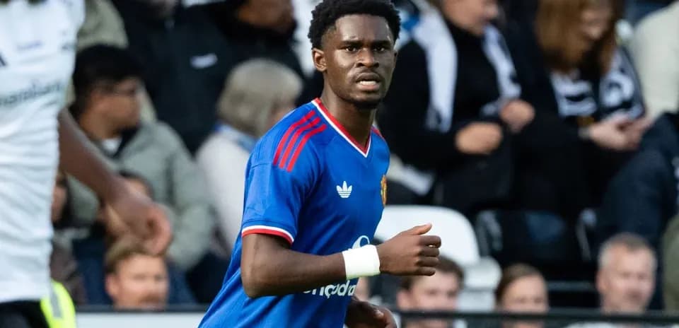 Futbolchi maydonda harakatda, tomoshabinlar ortida