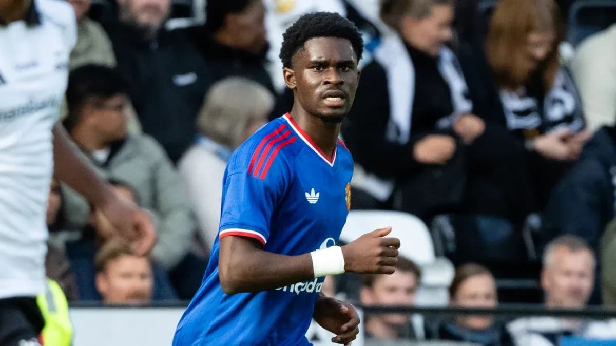 Futbolchi maydonda harakatda, tomoshabinlar ortida