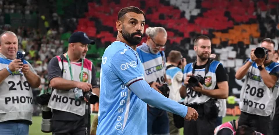 Futbolchi maydonda suratga olish uchun jurnalistlar orasida
