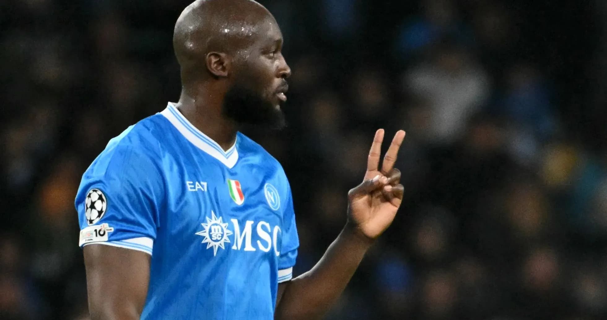 Futbolchi maydonda ikkita barmoq bilan ishora qilmoqda