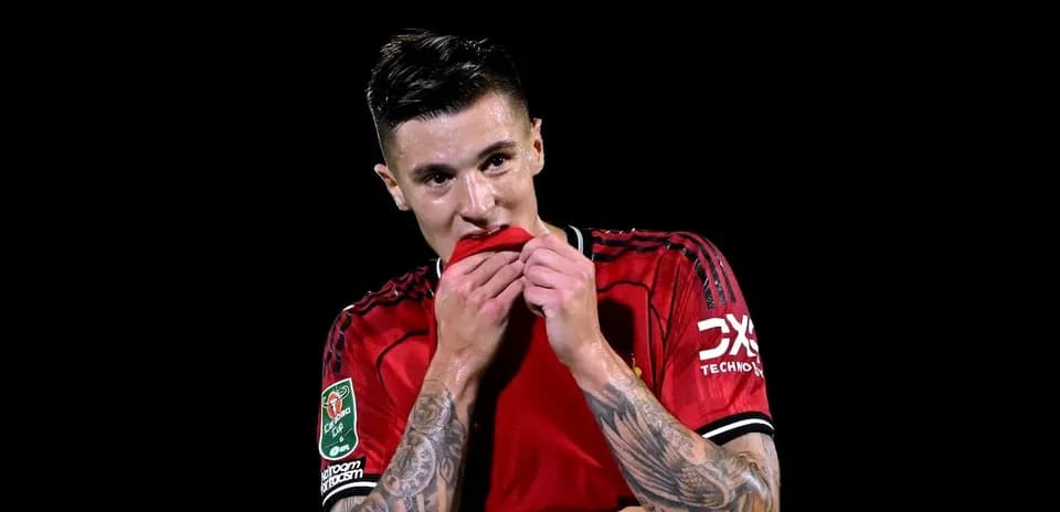 Futbolchi qizil forma kiyib, ko'ylagini tishlayapti