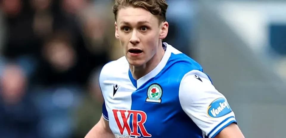 Futbolchi raqibga qarab yugurmoqda, Blackburn formasi