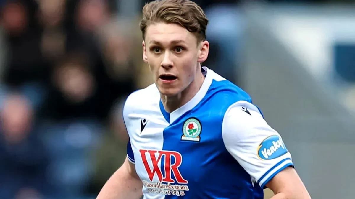 Futbolchi raqibga qarab yugurmoqda, Blackburn formasi
