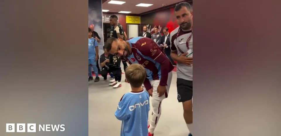 Futbolchi va kichkina bola kiyinish xonasida