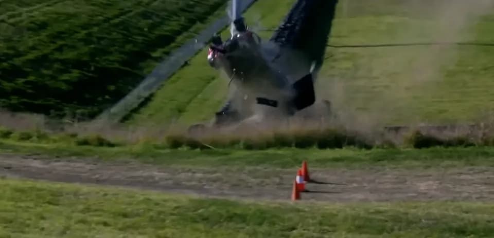 Helicopter crashing on grassy hillside