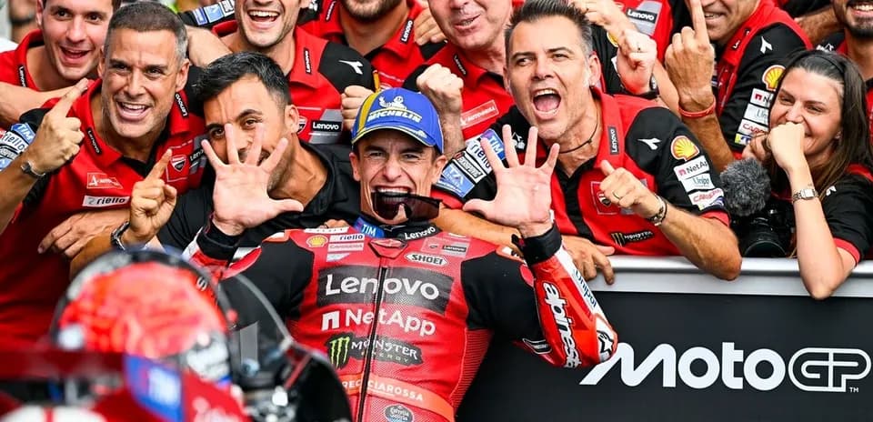 Ducati team celebrating victory with rider in center