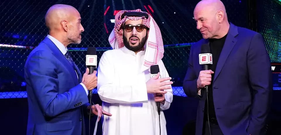 Three men speaking near UFC octagon during event