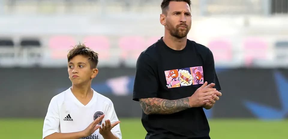 Lionel Messi and a boy applauding on field