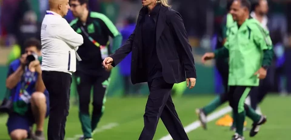Coach walking past staff on the sidelines